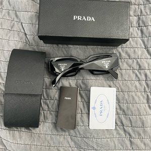 PRADA sunglasses. The logo on the left side is slightly worn shown in picture.